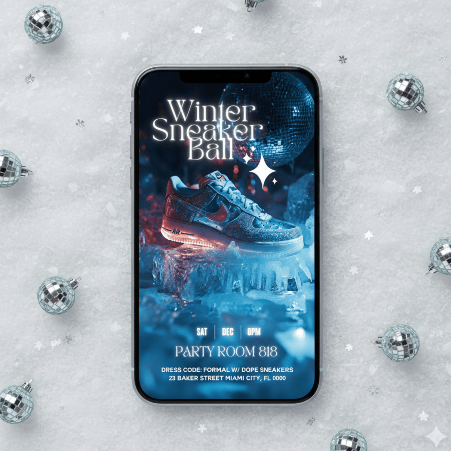 Smartphone displaying editable blue Winter Sneaker Ball invitation surrounded by small disco balls and glitter snow digital party invite template.